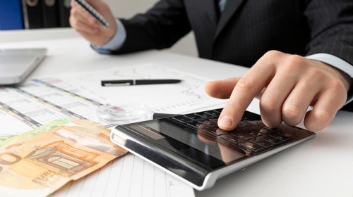 Business man calculating finance numbers close up
