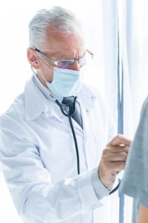 Doctor mask examining crop patient