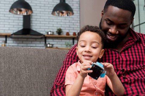 Black son father sitting with toy car