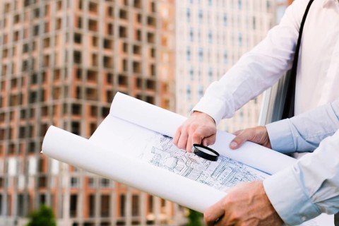 Close up people holding building sketch