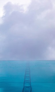 Rippled water surface during rain in swimming pool with dramatic cloudy sky