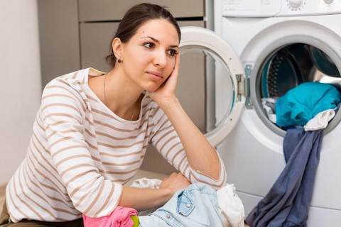 Tired woman doing laundry