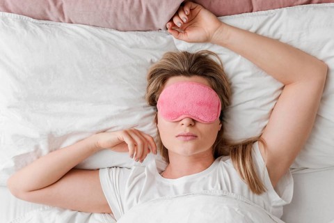 Female wearing sleep mask her eyes