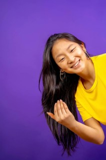 Vertical studio photo with purple background of chinese woman inviting to join with hand
