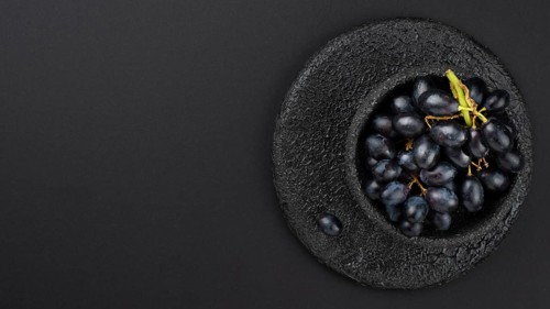 Black grapes bowl with copy space