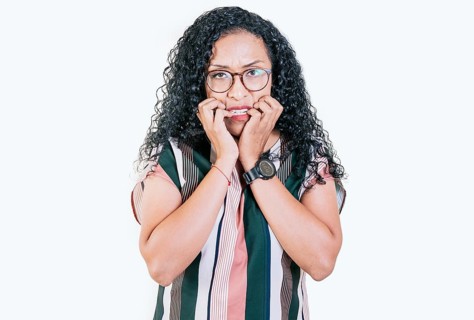 Worried young woman biting her nails isolated. Anxious afro woman biting her nails