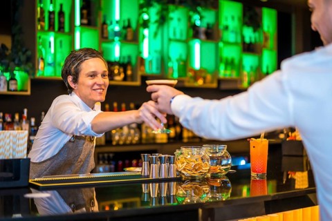 Bartender serving a martini cocktail in a luxury bar to a man