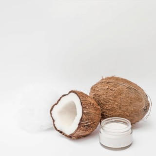 Close up moisturizing cream loofah coconut white backdrop