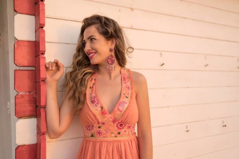 Portrait with copy space of a smiling distracted beauty woman leaning on a beach house