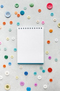 Empty notepad surrounded by colourful buttons