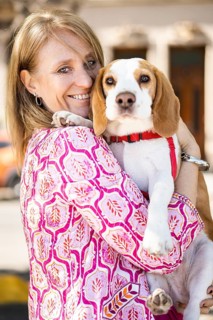 Female hugging friendly beagle dog enjoying happy moments while both look at camera