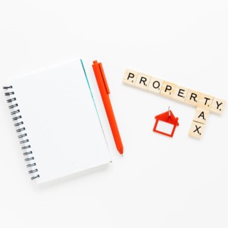 Top view spiral diary near wooden blocks with property tax text isolated white background