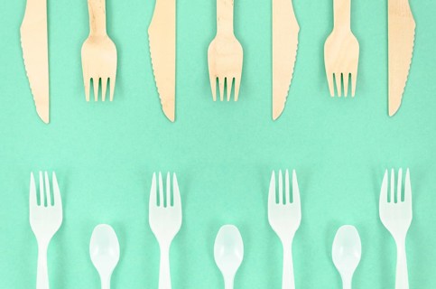 Colorful disposable cutlery turquoise background
