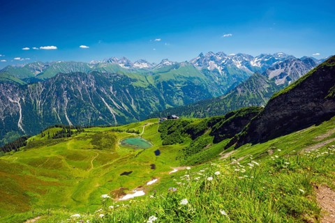Panorama from the Fellhorn over the Schlappoldsee and Fellhornbahn mountain station to the central main ridge of the Allgaeu Alps