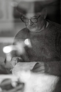 Senior expert luthier artisan violin maker carve sculpt chisel ribs of a new classical model cello in workshop Cremona Italy