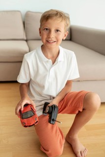 Front view kid playing with electric car