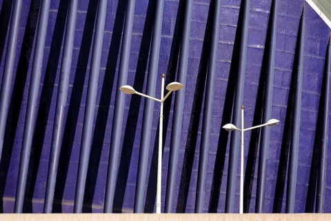 Streetlights in front of a blue facade