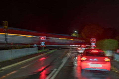 Train crossing a level crossing at night