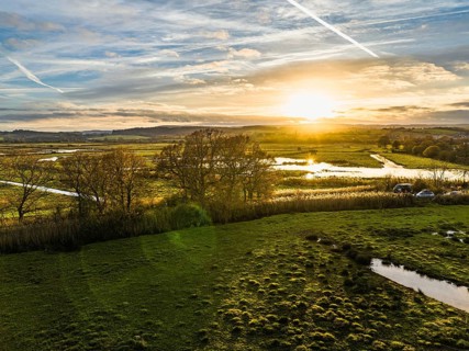 Sunset over Wetlands and Marshes in RSPB Exminster and Powderham Marshe from a drone