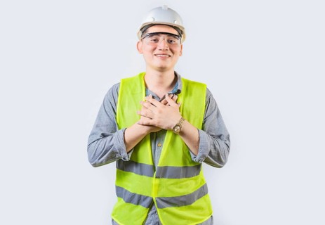 Portrait of young engineer with grateful gesture. Handsome grateful engineer with hands on chest isolated
