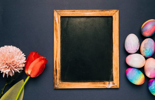 Blank blackboard with red tulip chrysanthemum easter eggs black background