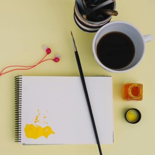 Brush notebook near coffee earphones