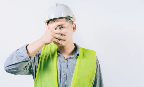 Man engineer with irritated eyes isolated. Young engineer with conjunctivitis on isolated background