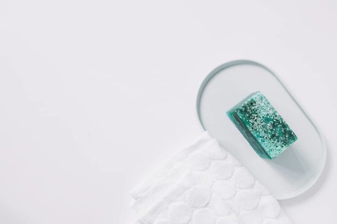 High angle view green soap bar napkin white backdrop