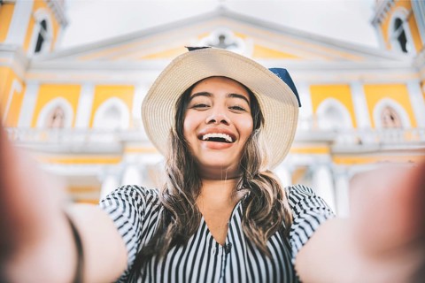 Happy tourist girl taking a selfie in a square. Girl lifestyle taking a self portrait in the square. Granada