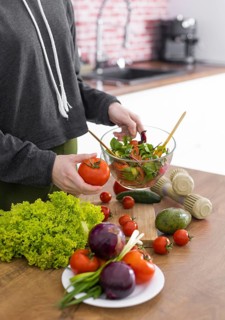 Close up hand holding bowl with tasty salad