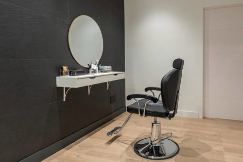 Interior minimalist space of a beauty salon with a chair and a mirror