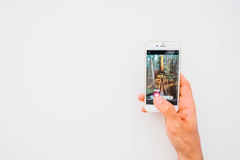 Hand holding phone with facebook copy space