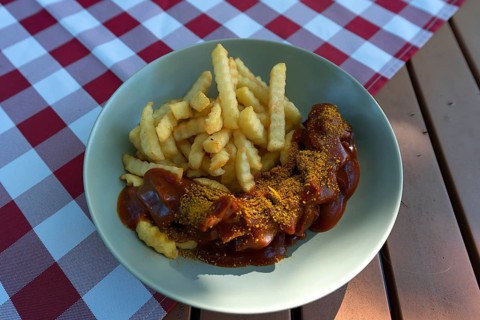 Currywurst with French fries served in a garden restaurant