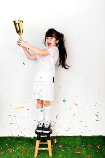 Football concept with girl celebrating with trophy