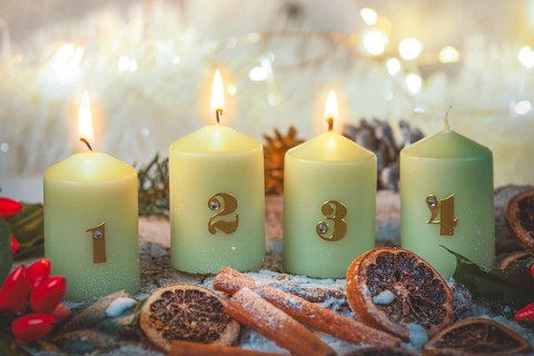 Advent candles surrounded by Christmas decorations