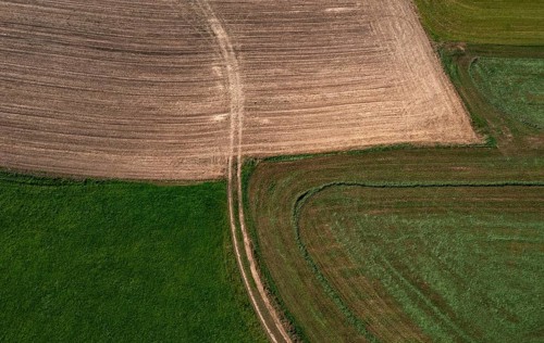 Drone view of green and ploughed fields with field path near Pabneukirchen