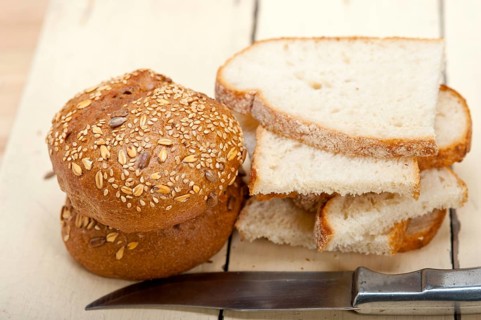 Fresh organic bread over rustic table macro closeup