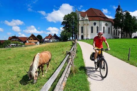 Cyclist with touring bike in front of the Wieskirche