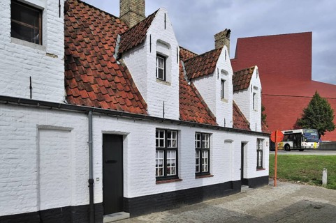 Alley with medieval almshouses and Concert Hall in Bruges