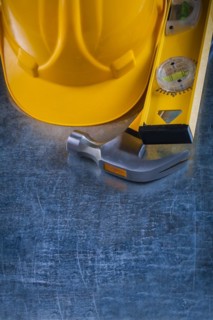 Copy space image of claw hammer construction level and building helmet on scratched metallic surface maintenance concept
