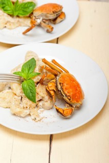 Fresh homemade Italian gnocchi with seafood sauce crab and basil