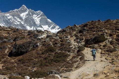 An independent trekker approaching Dingboche on a trek in the Everest Region. Lhotse