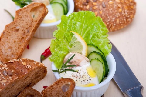 Fresh organic garlic cheese dip salad on a rustic table with bread