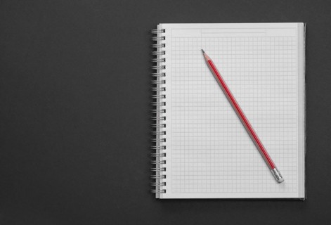Clean square copybook with red pen on black background education concept