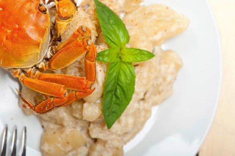 Fresh homemade Italian gnocchi with seafood sauce crab and basil