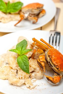 Fresh homemade Italian gnocchi with seafood sauce crab and basil