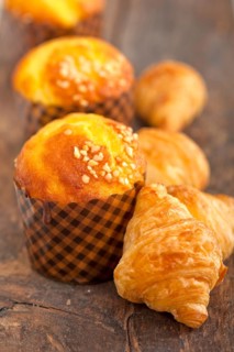 Fresh baked muffin and croissant mignon on old wood table