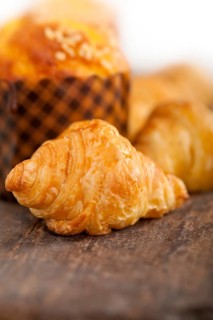 Fresh baked muffin and croissant mignon on old wood table