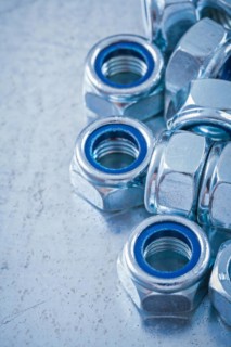 Collection of steel nuts on flat metallic background Construction concept