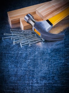 Copy room image of construction nails hammer and wooden bricks on scratched metallic surface maintenance concept